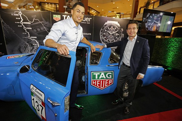 Giancarlo Stanton, Miami Marlins right fielder, and Hilaire Damson, racecar driver, celebrate at the TAG Heuer 100 Years of Innovation exhibit.